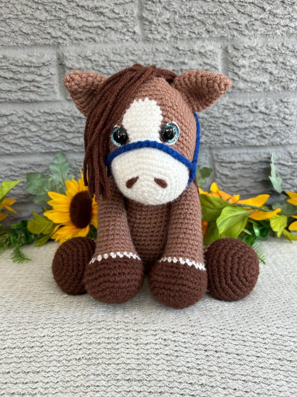 Photo of our brown crocheted horse with blue reins