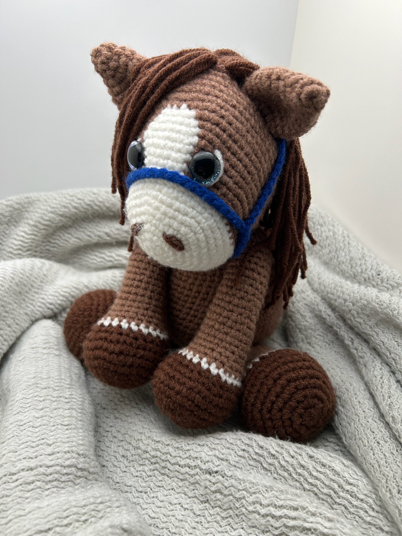 Photo of our brown crocheted horse with blue reins