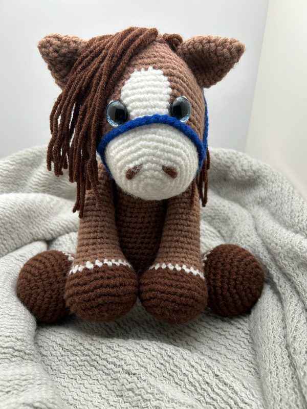 Photo of our brown crocheted horse with blue reins