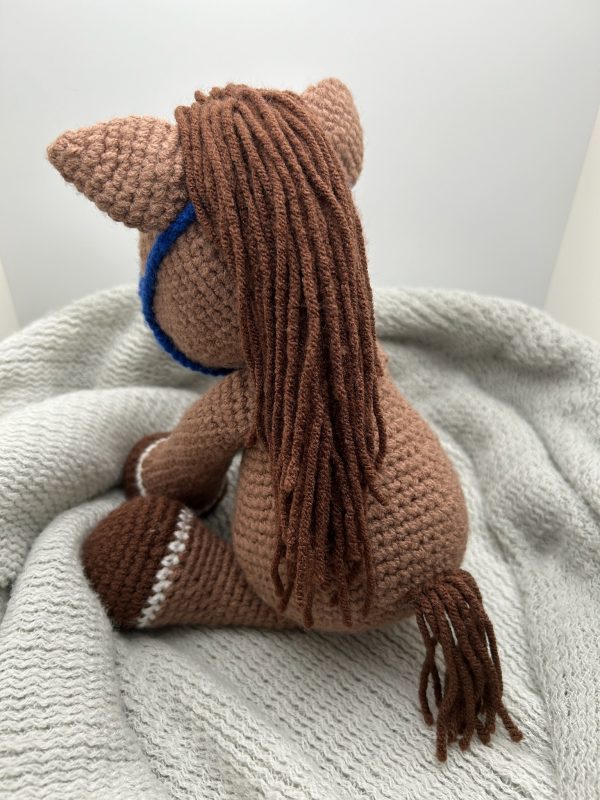 Photo of our brown crocheted horse with blue reins