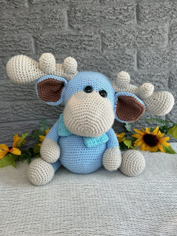 photo of crocheted moose, with a blue body and bright blue bow