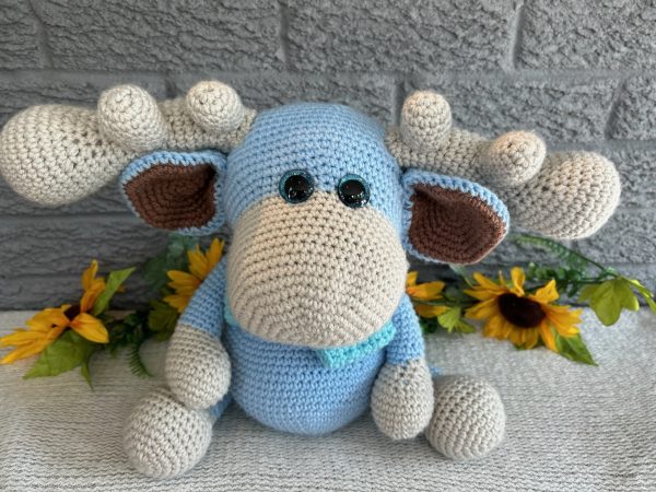 photo of crocheted moose, with a blue body and bright blue bow