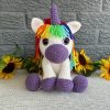 Photo of a crocheted unicorn with purple accents and rainbow mane