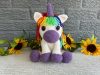 Photo of a crocheted unicorn with purple accents and rainbow mane