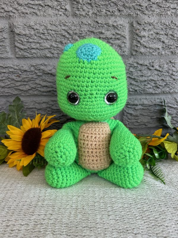 Photo of our crocheted stuffed turtle in bright green with a brown shell