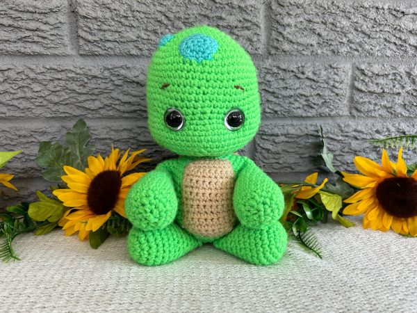 Photo of our crocheted stuffed turtle in bright green with a brown shell