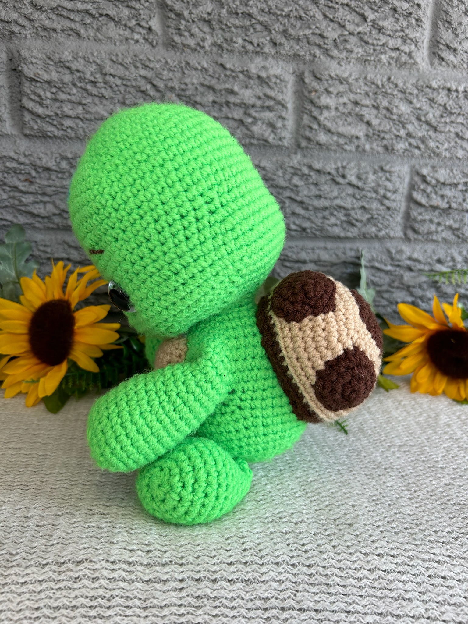 Photo of our crocheted stuffed turtle in bright green with a brown shell