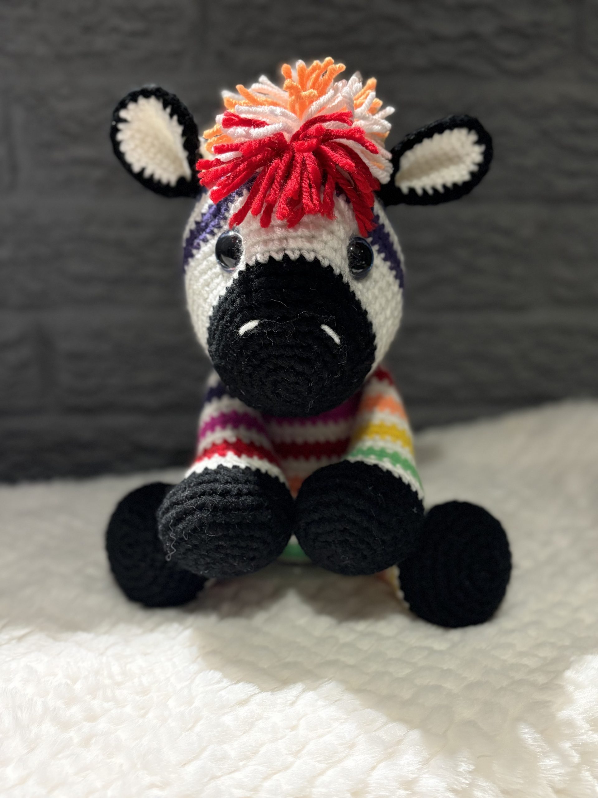 Close-up of handmade crocheted rainbow zebra