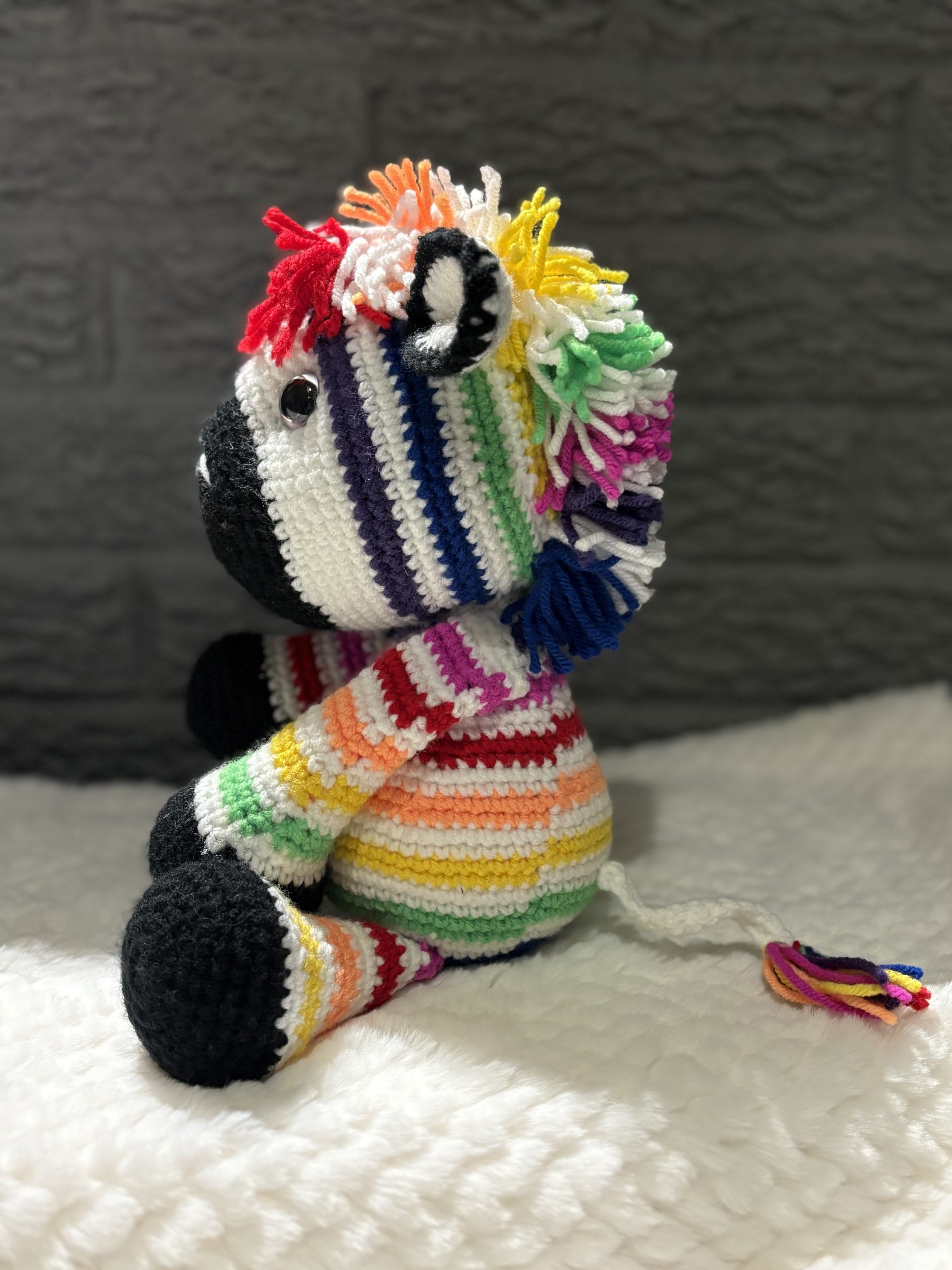 Side view of handmade crocheted rainbow zebra
