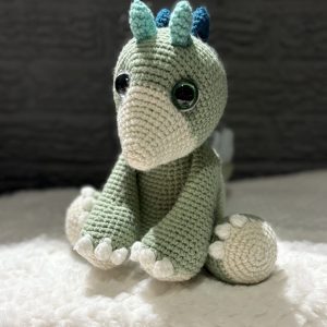 Handmade crochet dinosaur plush sitting upright