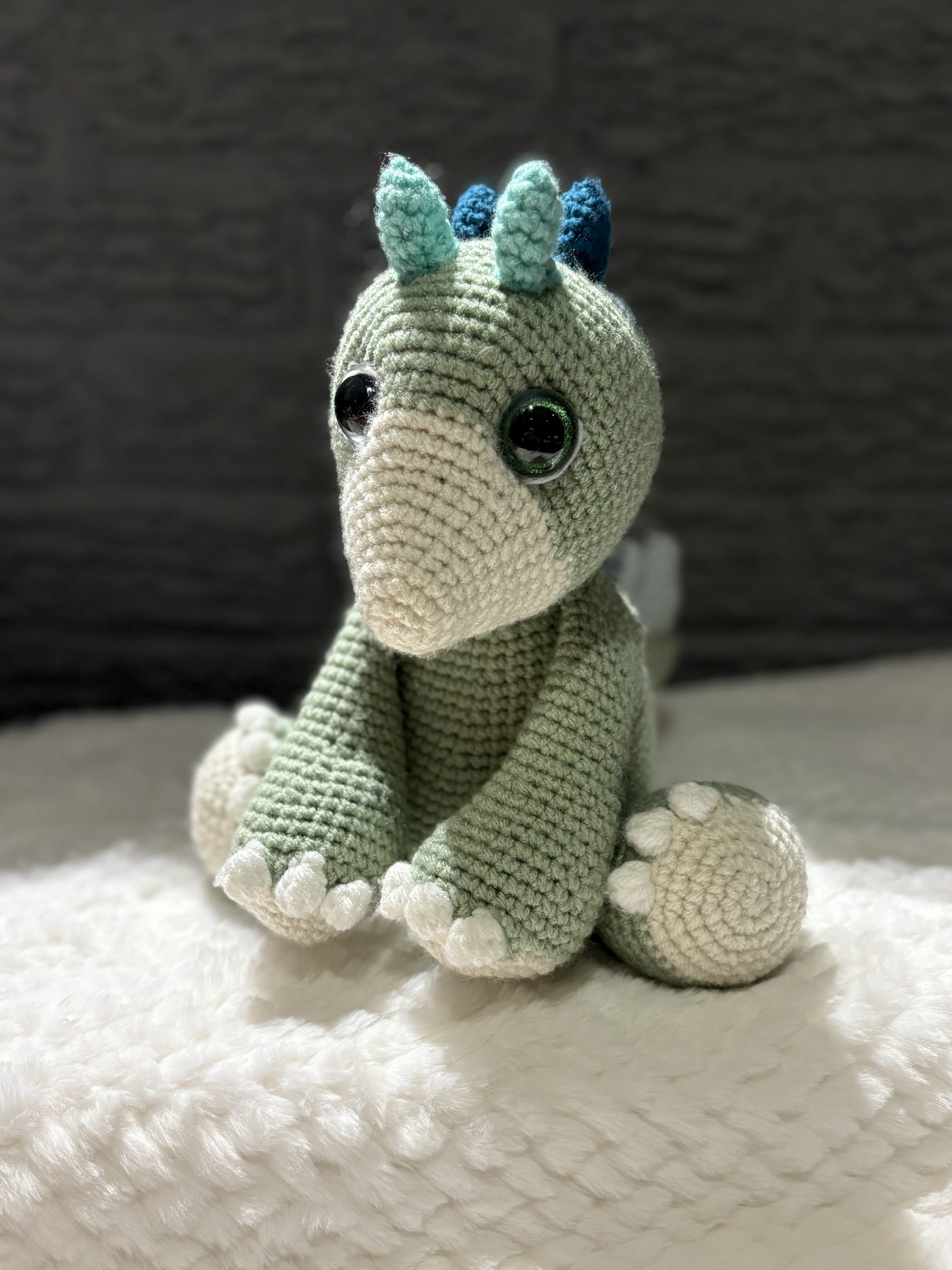 Handmade crochet dinosaur plush sitting upright