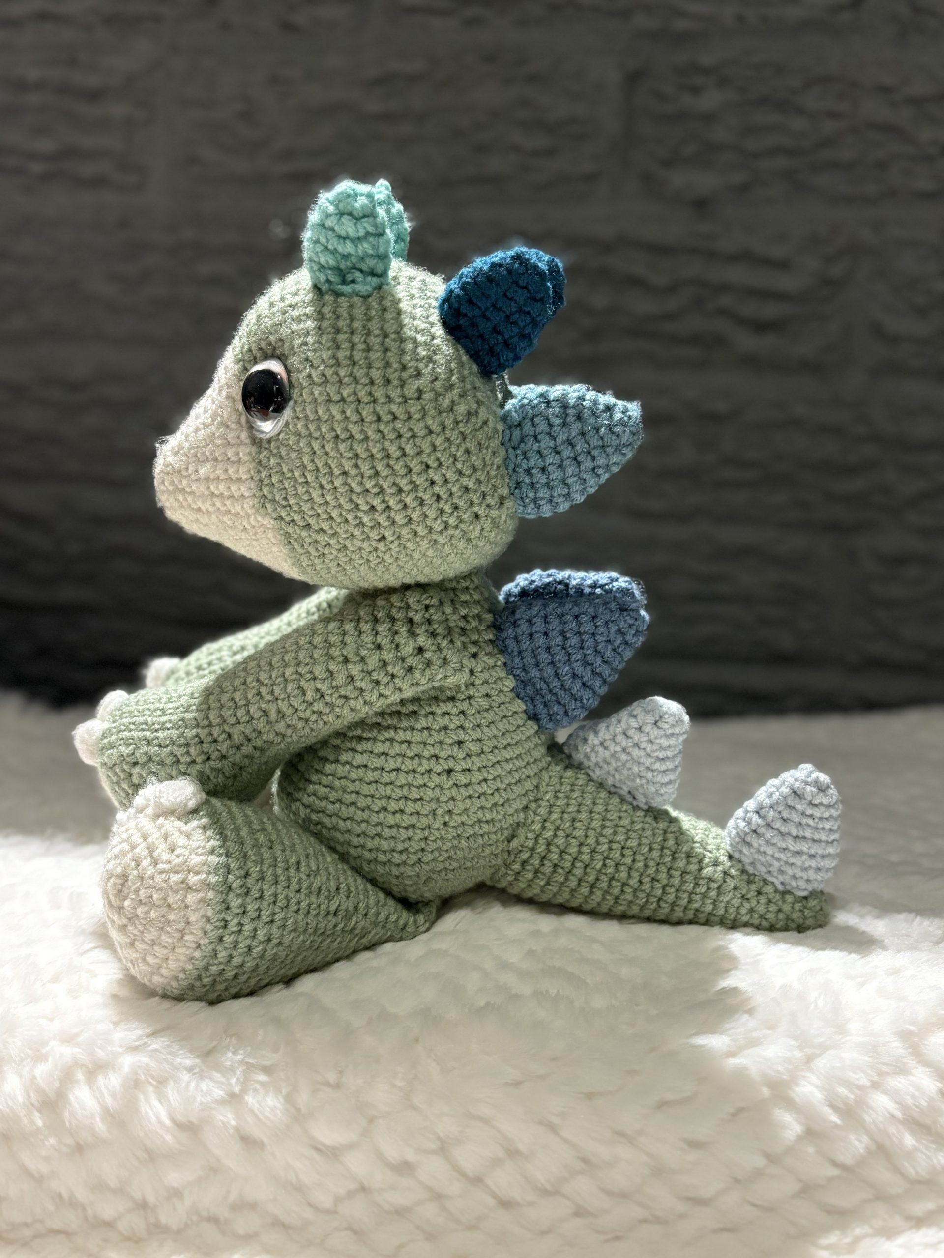 Side view of handmade crochet dinosaur plush