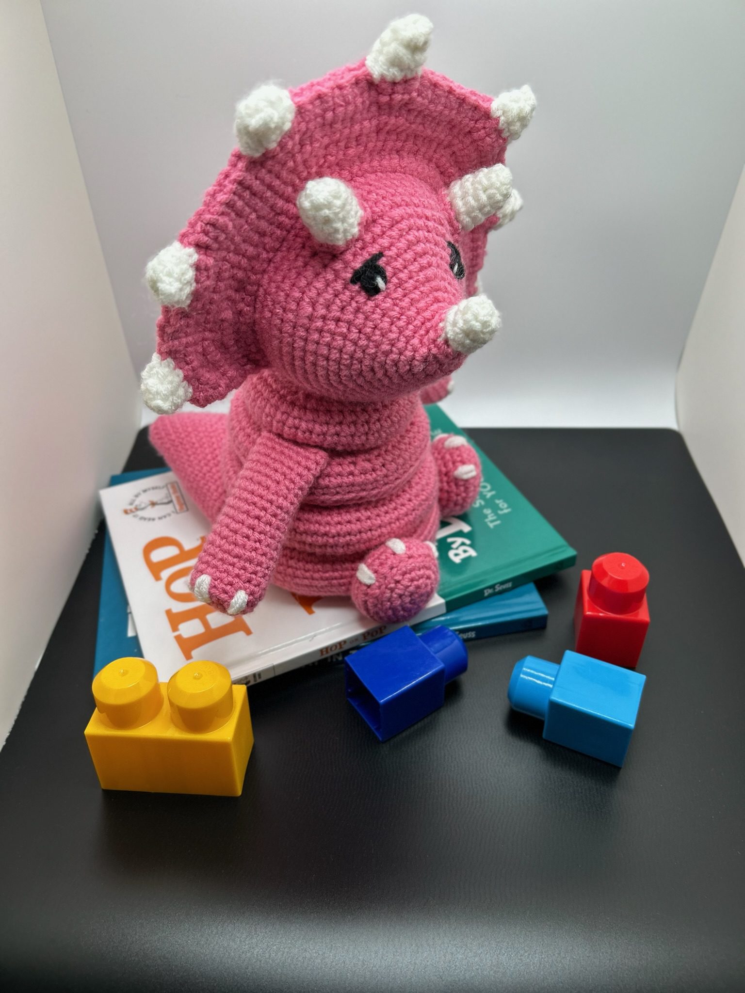 Side view of handmade crocheted dinosaur stacking ring toy