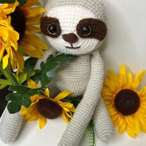 crocheted-sloth-flower-bg.jpg Close-up of handmade crocheted sloth