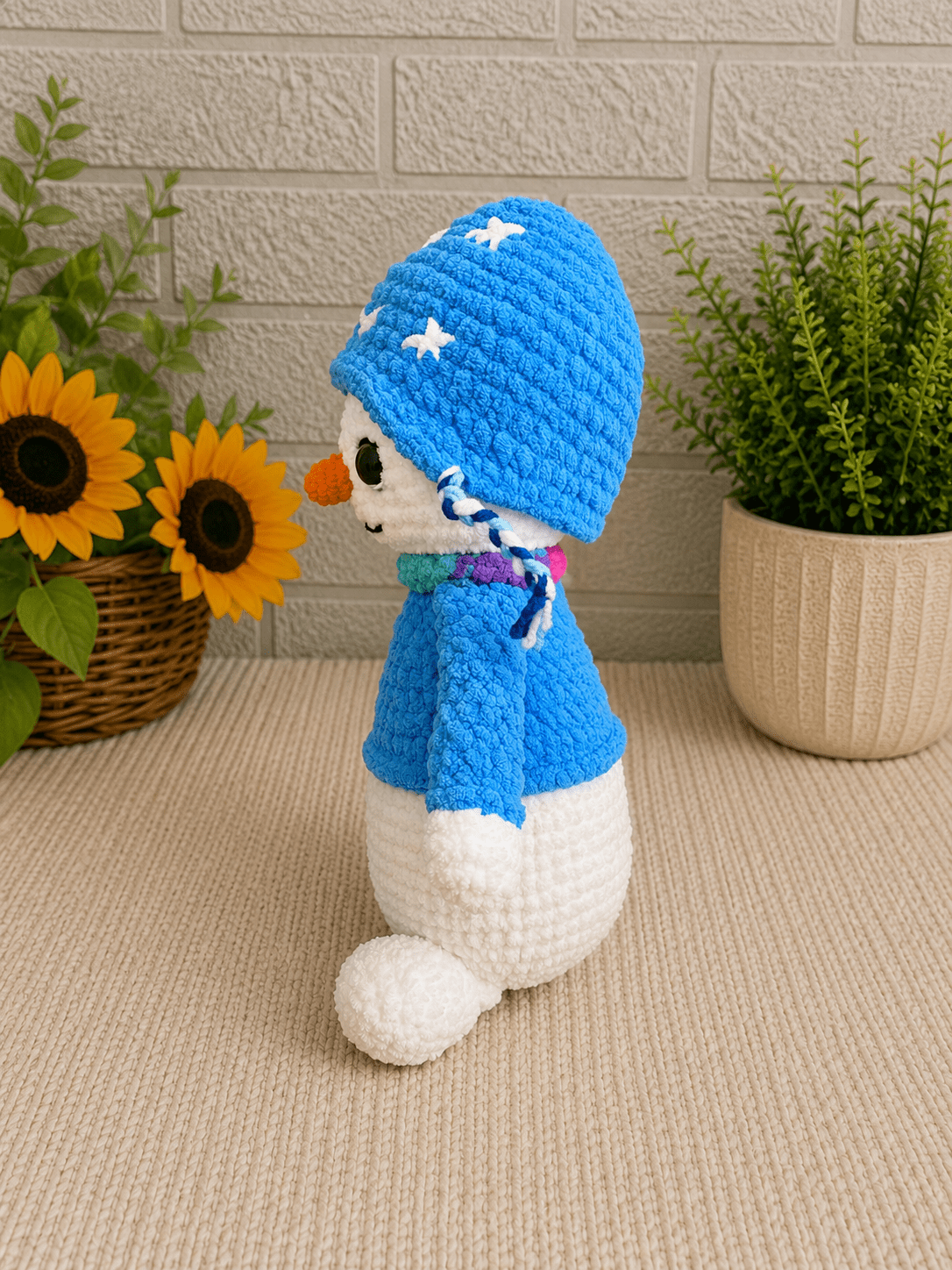 Side view of handmade crochet winter snowman plush.